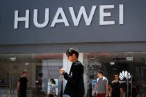 People walk past a Huawei retail store in Beijing, Sunday, June 30, 2019. Once again, President ...
