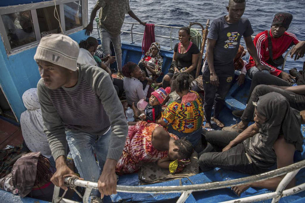 Migrants rest after being rescued at sea by the Open Arms aid boat on Sunday June 30, 2019. A h ...