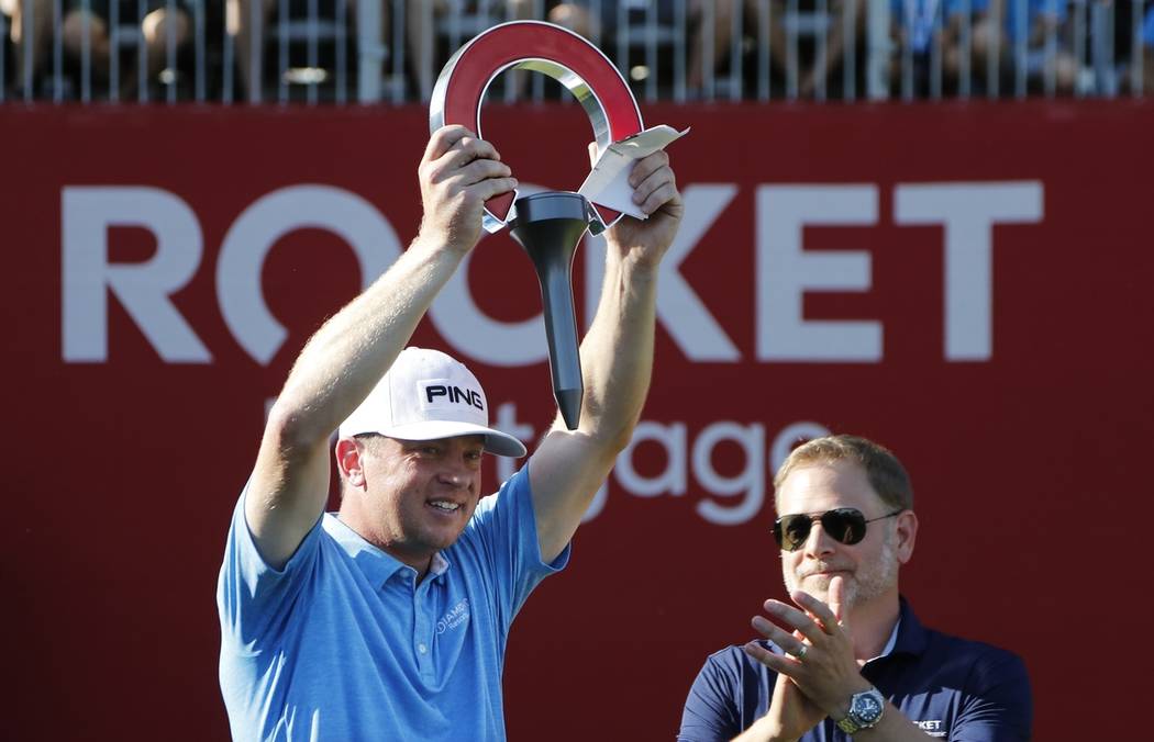 Nate Lashley raises the winner's trophy after the final round of the Rocket Mortgage Classic go ...