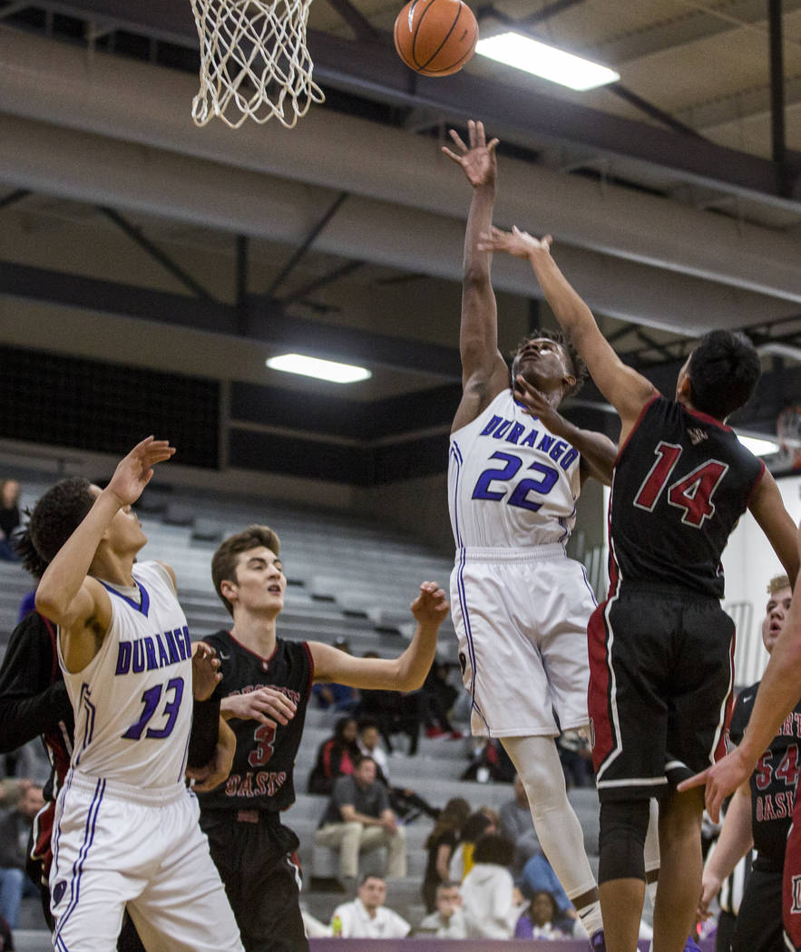 Durango’s Vernell Watts (22) attempts a layup while Anthony Swift (13) watches and Des ...
