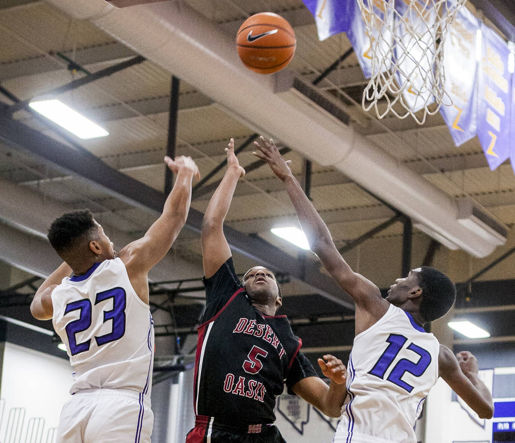 Desert Oasis’ Manny Mitchell (5) reaches for the ball along with Durango’s Nicqu ...