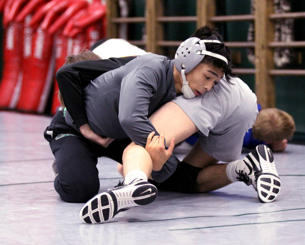 Green Valley High School junior wrestler Steele Dias, top, works on a move with his training ...