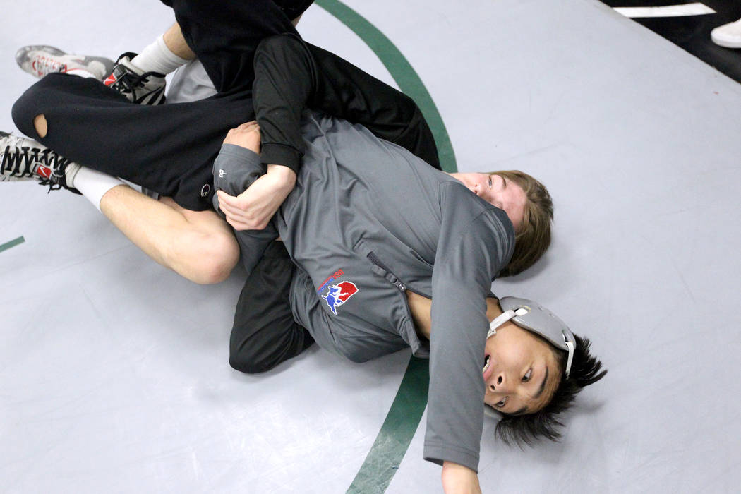 Green Valley High School junior wrestler Steele Dias, right, works on a move with his traini ...