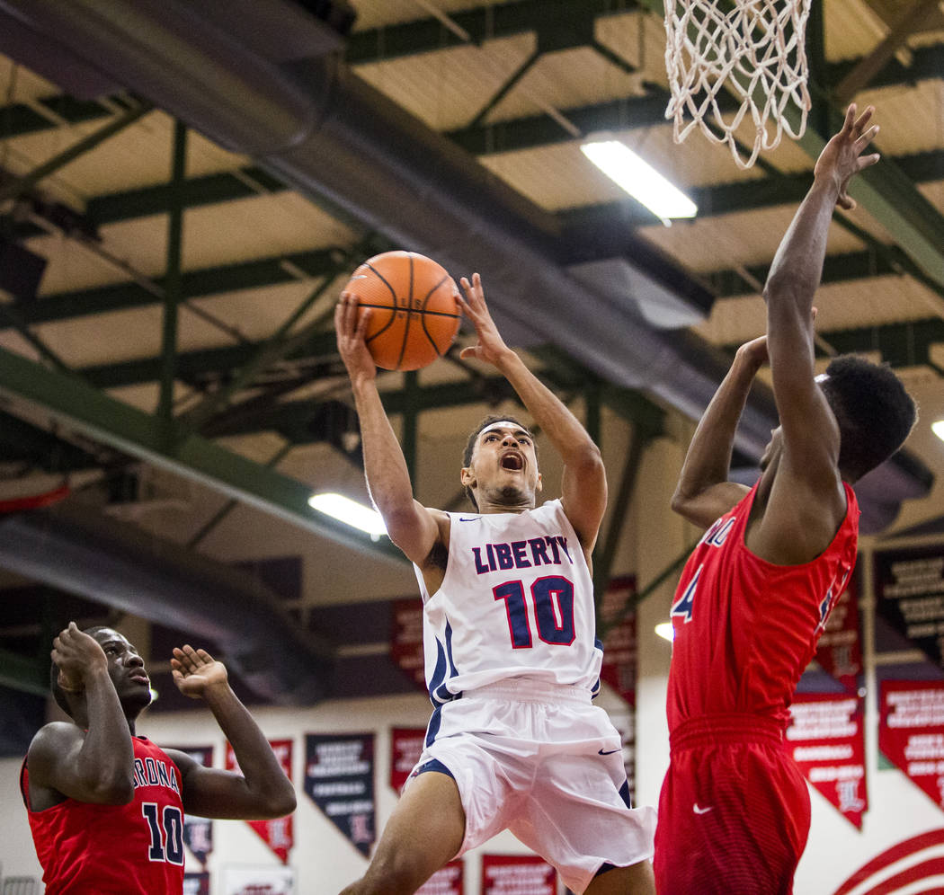 Liberty’s Jordan Holt (10) goes up for a shot while Coronado’s Taieem Comeaux (4 ...