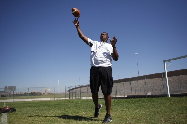 Randall Cunningham, Silverado High School head football coach, throws the ball during practi ...