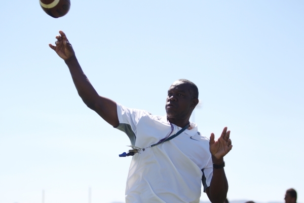 Randall Cunningham, Silverado High School head football coach, throws the ball during practi ...