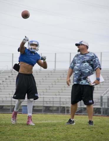 Basic football coach Jeff Cahill watches as quarterback Aeneas "Tank" McAllister t ...