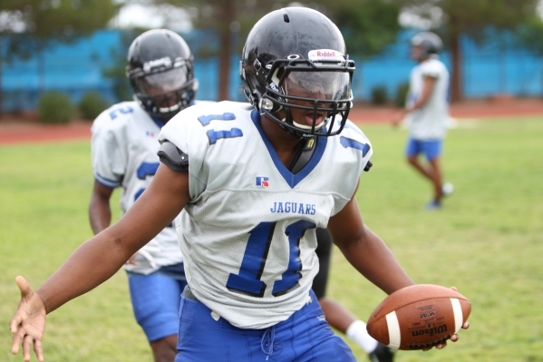 Desert Pines Marckell Grayson (11) reaches his hand to a teammate for a high five during foo ...
