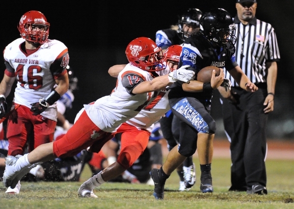 Desert Pines running back Trevor Nofoa (23) is tackled by Abor View‘s Noah Noce (12) a ...