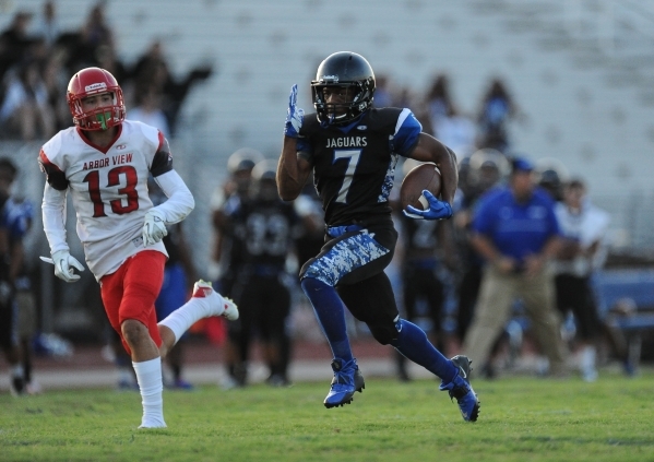 Desert Pines running back Isaiah Morris races past Arbor View defensive back Mike Sims for a ...