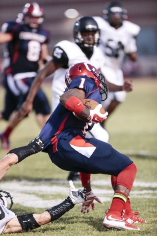 Coronado High School‘s DJ Davis Jr. (1) makes a move with the ball as he is being held ...