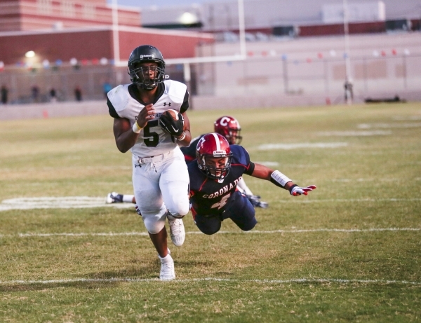 Palo Verde running back Christian Bell averts a diving tackle attempt by Coronado‘s Ju ...