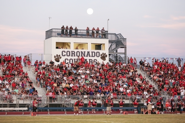The moon rises behind the spectators watching from the Coronado side of the field during a f ...