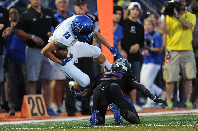 Bishop Gorman defensive back Tyjon Lindsey (25) trips up Chandler wide receiver Taj De Carri ...