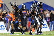 Bishop Gorman safety Damuzhea Bolden, left, and teammates celebrate a Chandler fumble in the ...