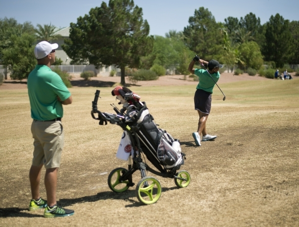 Rancho High School golf coach Anthony DiOrio, left, watches as Aubrianna Jordan hits a ball ...