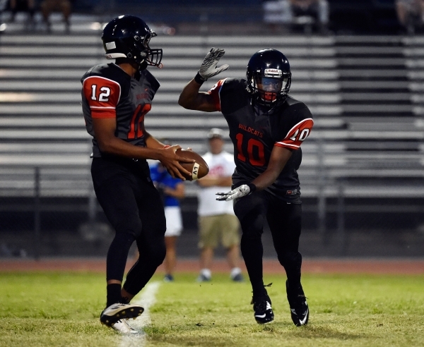 Las Vegas quarterback Zach Matlock (12) appears to hand off the ball to Elijah Hicks during ...