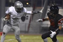 Green Valley‘s Nahzi Salih (9) holds Las Vegas‘ Cody Kludasch on a punt return d ...