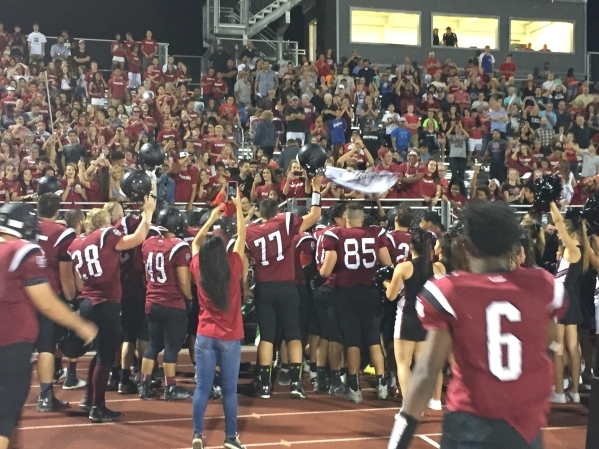 Members of Desert Oasis‘ football team celebrate with fans after the team‘s 19-6 ...
