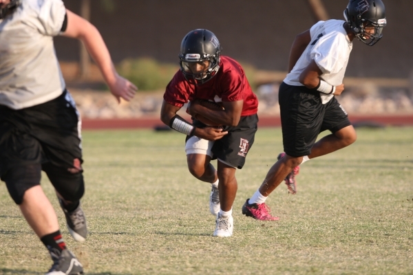 Running back Tyshun McClinton, center, participates in football practice at Desert Oasis Hig ...