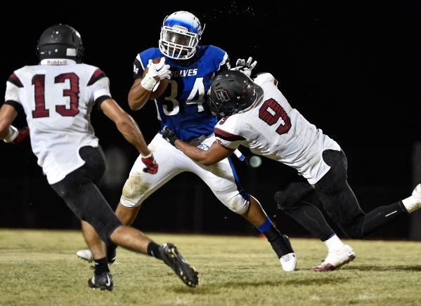 Basic‘s Sean White (34) looks for a hole against Desert Oasis‘ Alec Gomez (13) a ...