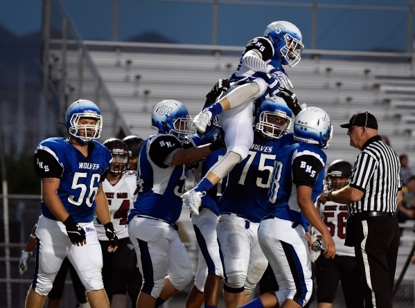 Basic&lsquo;s Jake Waldren (25) celebrates with his teammates after scoring a touchdown agai ...