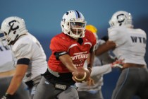 Centennial quarterback Jamaal Evans hands off the ball during their football practice at Cen ...