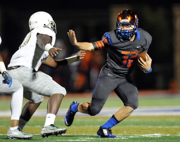 Bishop Gorman quarterback Tate Martell (18) stiff-arms Long Beach Poly Jackrabbits middle li ...