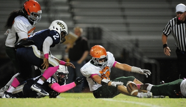 Mojave Rattlers linebacker Wesley Patton, center, and Spring Valley Grizzlies running backs ...
