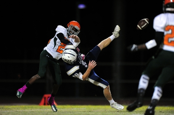 Mojave Rattlers cornerback Lee Ewell, left, slams into Spring Valley Grizzlies punt returner ...