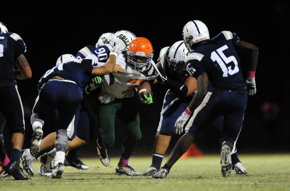 The Spring Valley defense wraps up Mojave running back Khalid Walker, center, in the third q ...