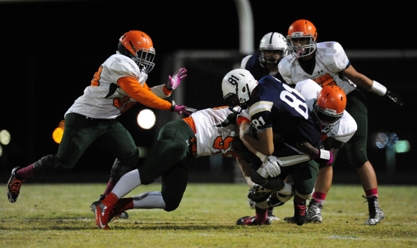 The Mojave Rattlers defense wraps up Spring Valley Grizzlies wide receiver Sal Everett (81) ...
