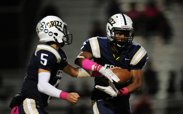 Spring Valley Grizzlies quarterback K.C. Moore (5) hands off to running back Marcus Dawson ( ...