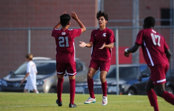 Cimarron-Memorial forward Arturo Behena high fives Miguel Rodriguez (21) after Behena scored ...