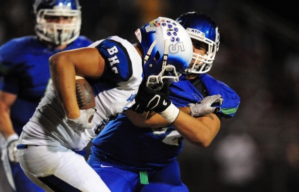 Green Valley Gators defensive lineman Luisenrique Lopez, right, grabs the facemask of Basic ...