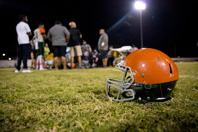 The helmet of injured Mojave player Elijah Smoot (3) remains on the field while he is tended ...