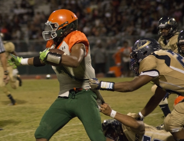 Mojave&lsquo;s Khalid Walker (7) tries to break tackles as he runs the ball during their pre ...
