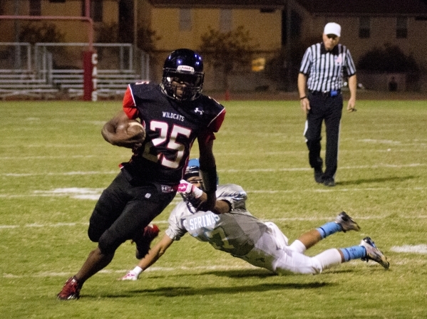 Las Vegas‘ DiQuan Brown (25) breaks a tackle on his way up field during their prep foo ...