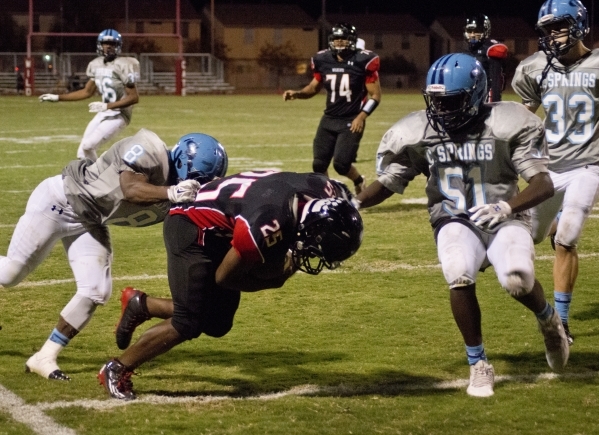 Las Vegas‘ DiQuan Brown (25) lowers his helmet for additional yardage during their pre ...
