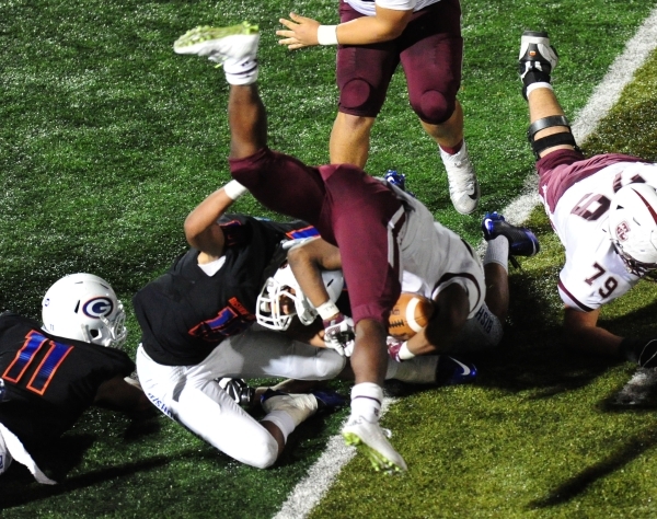 Don Bosco running back Malik Bakker is upended by Bishop Gorman linebacker Palaie Gaoteote ( ...