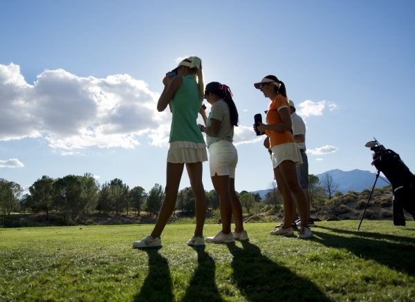 Annick Haczkiewicz of Palo Verde High School, center, measures the distance to the hole duri ...