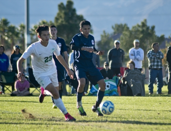 Green Valley‘s Alex Gibson (23) attempts to work the ball around Coronado‘s Nico ...