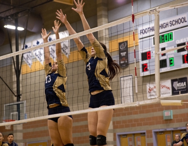 Foothill‘s Alyssa McCoy (13) and Tessa Michalosky (9) jump to block the ball during th ...
