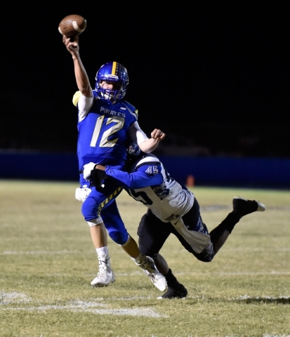 Moapa Valley quarterback Nate Cox passes the ball under pressure from Desert Pines‘ Ja ...