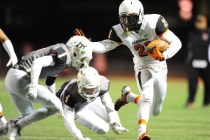 Chaparral wide receiver Casey Acosta (21) attempts to stiff-arm Faith Lutheran defensive bac ...
