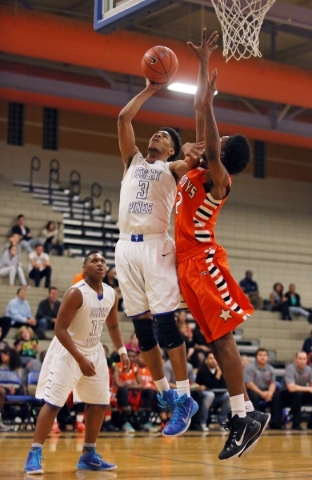 Desert PinesÃ­ Trevon Abdullah, center, goes for a lay-up against Chaparral‘s Mahari ...