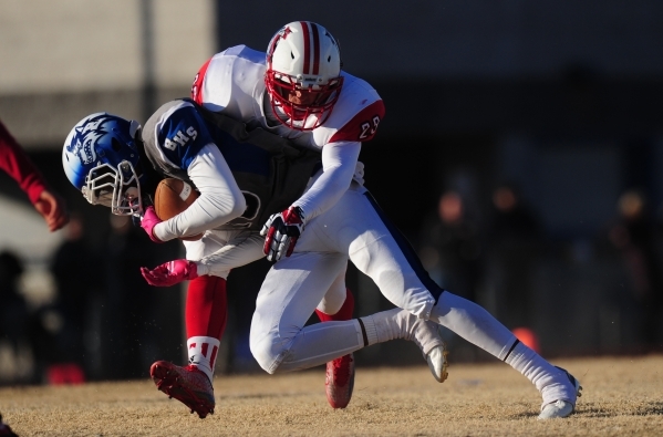 Liberty linebacker Alan Ewell (29) tackles Basic Wolves wide receiver De‘Shawn Eagles ...