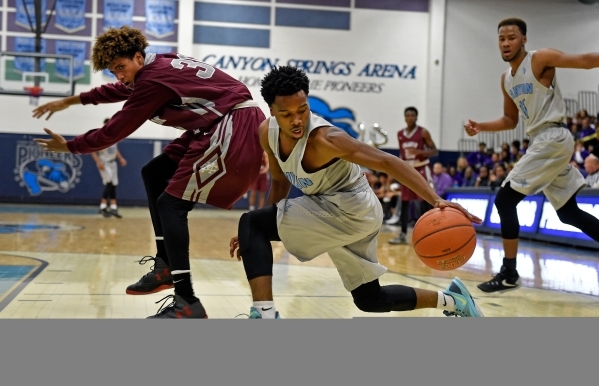 Canyon Springs‘ Laymon Jackson, right, grabs a loose ball from Cimarron-Memorial&lsquo ...