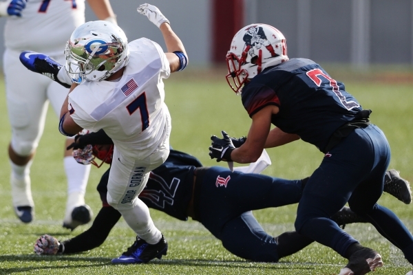 Bishop Gorman‘s Biaggio Ali Walsh (7) is tackled by Liberty‘s Alan Mwata (42) in ...