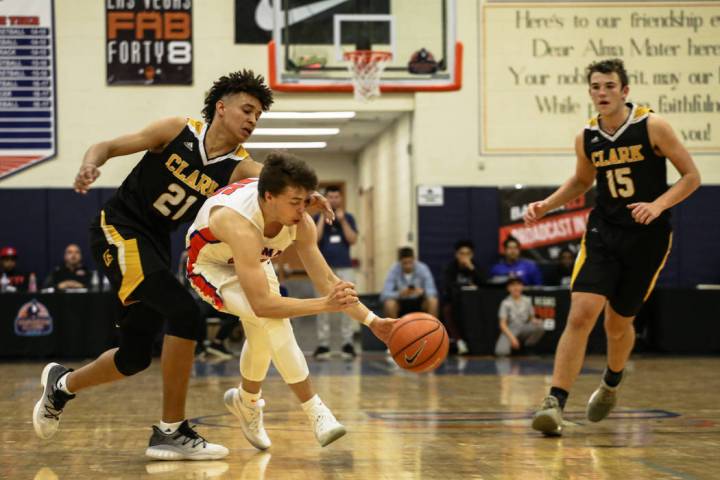 Clark Chargers’ Jalen Hill (21) knocks the ball away from Bishop Gorman’s Chance ...